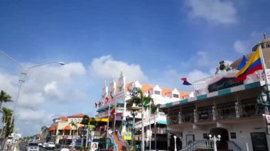 Oranjestad Aruba 'daki renkli Royal Plaza alışveriş merkezinin önünde yürüyorum.