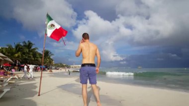 Güzel kaslı bir Avrupalı Playa del Carmen Yucatan, Meksika sahillerinde yürüyor.