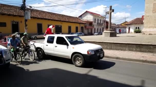 圣诞老人开车穿过尼加拉瓜格拉纳达大街时从车上扔糖果 — 图库视频影像
