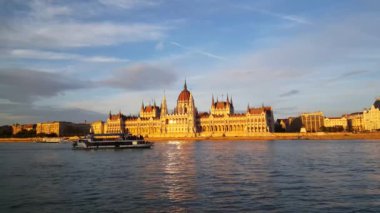 Macaristan Parlamento Binası (Budapeşte Parlamentosu) akşam ışığında bir yolcu gemisinin geçişi ile