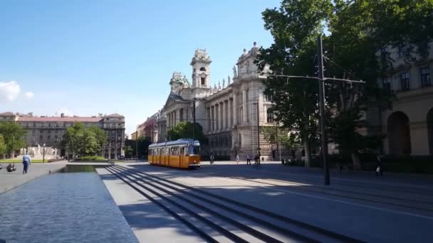 ハンガリーのブダペストにあるハンガリー議会議事堂 ブダペスト議会 広場を通る黄色いトラム — ストック動画