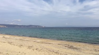 Arka planda Pyrgadikia kasabası olan plaj