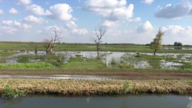 Macaristan 'daki Hortobgy Ulusal Parkı' ndaki büyük bir göl üzerindeki bir gözlem kulesinden Avrupa 'nın en büyük yarı doğal çayırı görünüyor.