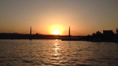 İstanbul 'da Atatrk Köprüsü ile büyük bir şehir su yolu olan The Golden Horn Hali' de feribotla gün batımı