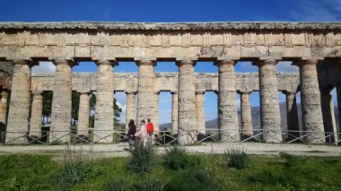 İtalya 'daki Segesta Doric tapınağından geçen turistler