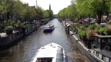 Amsterdam 'da kanalın kenarında yaşayan teknelerle kanala giden gemiler.