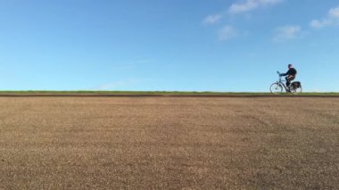 Wierum Friesland, Hollanda 'da bir lezbiyenin üzerinde bisiklet süren bir adam.