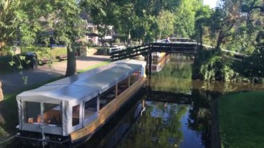 Kadın Giethoorn 'da bir köprüden geçiyor Hollanda' da