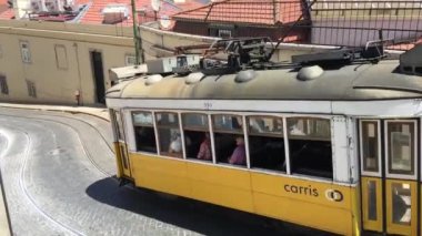 Lizbon 'un eski bir kasabasından geçen sarı bir tramvay.