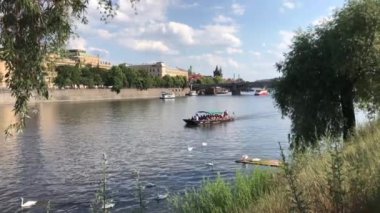 Prag Çek Cumhuriyeti 'ndeki Vltava nehrinde turistlerle dolu küçük bir tekne.