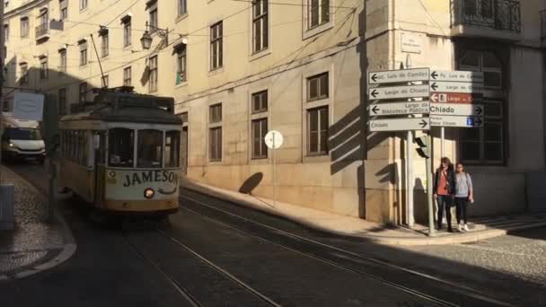 リスボンポルトガルの旧市街を通る黄色の路面電車に続くパン — ストック動画