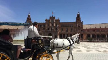 Atlar ve arabalar Sevilla İspanya 'daki Plaza de Espana Pınarında Pınar' da dolaşıyorlar.