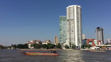 Wat Yannawa tapınağından Bangkok manzaralı Chao Phraya nehrindeki uzun kuyruklu tekne.