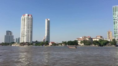 Wat Yannawa tapınağından Bangkok manzaralı Chao Phraya nehrindeki uzun kuyruklu tekne.