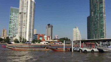 Uzun kuyruklu tekne Wat Yannawa tapınağının önündeki rıhtımdan ayrılıyor.