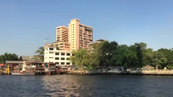 チャオプラヤ川沿いの建物のフェリーからの眺めタイのバンコクを通るフェリー — ストック動画