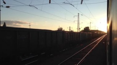 Rusya 'da gün batımında tren istasyonundan ayrılıyor.