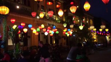 Renkli fenerler ve geceleri Hoi An Vietnam sokaklarında yürüyen insanlar.