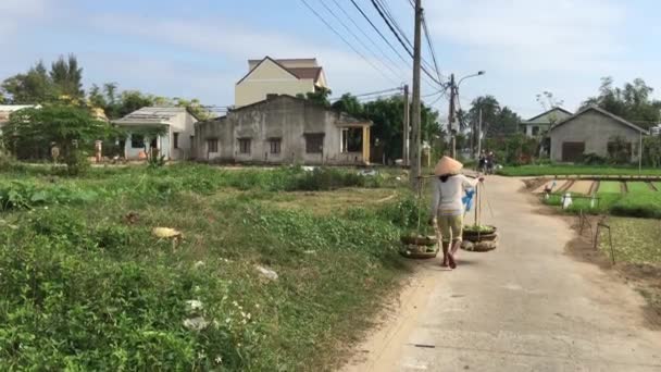ベトナム人女性はベトナムのホイアンの田舎で食べ物と一緒に歩く — ストック動画