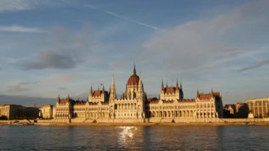 Macaristan 'ın Budapeşte kentindeki Tuna nehrindeki Macar Parlamento Binası' na giden yolcu gemileri ve feribot seferlerinden günbatımında zaman aşımı