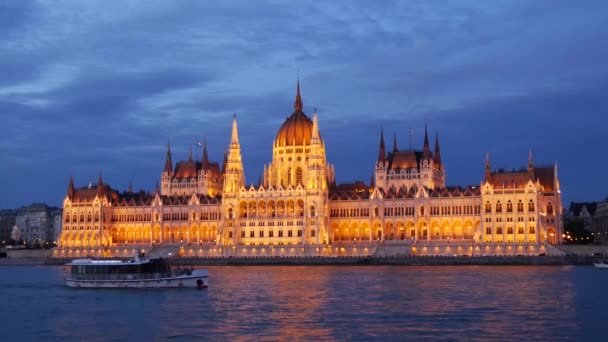 クルーズ船とハンガリー議会とのフェリーブダペストのドナウ川での夜の建物 ハンガリー — ストック動画