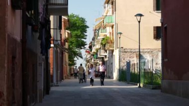 İtalya 'da Murano Venedik caddesinde yürüyen yerel halk