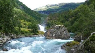 Morkidsdalen parkında açık mavi bir nehirde büyük bir taş Skjolden Norveç