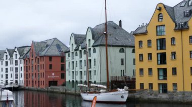 Alesund Norveç 'teki renkli evlerin önündeki yelkenli.