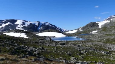 Norveç 'teki Jotunheimen Ulusal Parkı' nda dağların önünde karlı göl