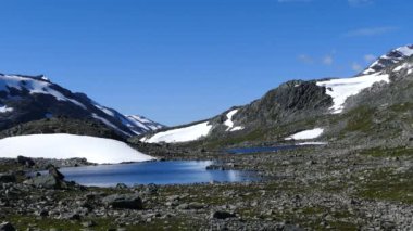 Norveç 'teki Jotunheimen Ulusal Parkı' nda dağların önünde karlı göl