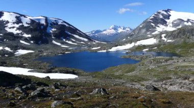 Norveç 'teki Jotunheimen Ulusal Parkı' nda dağların önünde karlı göl