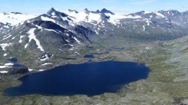 Norveç 'in Jotunheimen Ulusal Parkı' ndaki bir gölden ve karlı dağlardan Pan