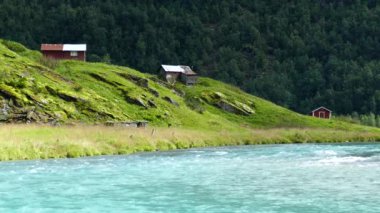 Morkidsdalen Parkı 'ndaki nehir ve göl kenarındaki kulübeler Skjolden Norveç