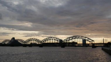 Riga Letonya 'da gün batımında Demiryolu Köprüsü