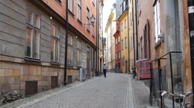 Gamla Stan 'de bir sokakta yürüyen adam Eski Stockholm kasabası İsveç