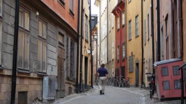Gamla Stan 'de bir sokakta yürüyen adam Eski Stockholm kasabası İsveç