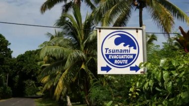 Rarotonga Cook Adaları 'ndaki yolun yanındaki tsunami tabelası.
