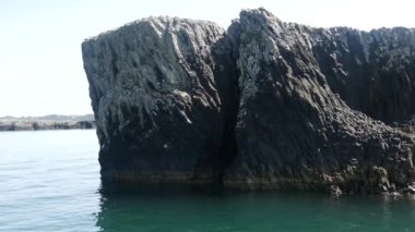Yeni Zelanda 'daki Adalar Körfezi' ndeki kayalara çok yakın seyrediyor.