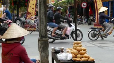 Vietnamlı kadın Hoi An Vietnam 'daki bir kavşakta ekmek satıyor.