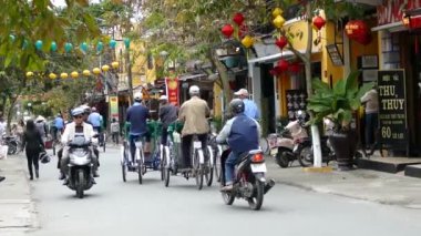 Eski Hoi An Vietnam 'ın caddesinde grup bisikleti sürücüleri.
