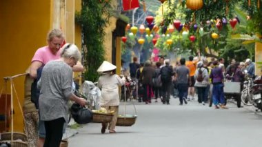 Büyük bir Asyalı turist grubu eski Hoi An Vietnam 'da yürüyor.