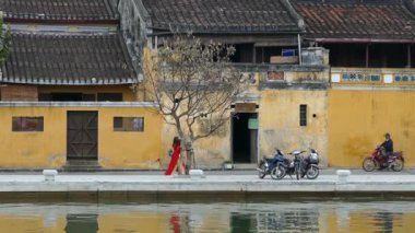 Eski Hoi An Vietnam kasabasındaki nehir cephesinde geleneksel Vietnam kıyafetleriyle Çinli turistler.