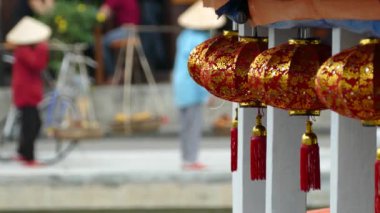Arka planda Vietnamlı kadınların Hoi An Vietnam 'dan geçtiği bir teknede kırmızı fenerler.