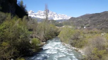 İspanya 'da El Pueyo de Jaca çevresindeki nehir ve karlı dağ manzarası