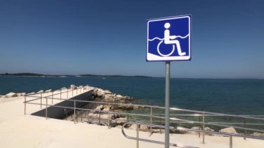 Hırvatistan 'da bir plajda tekerlekli sandalye tabelası