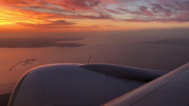 IJsselmeer üzerinden Amsterdam 'daki Schiphol Havaalanı' na doğru uçan günbatımı Hollanda