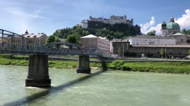 Salzburg, Avusturya 'daki Salzach nehrinin üzerindeki Mozartsteg köprüsüne doğru yürüyorum.