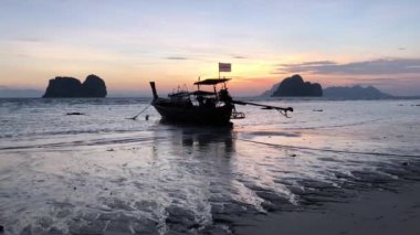 Tayland 'daki Koh Ngai adasında uzun kuyruklu bir tekneyle gün doğumu.