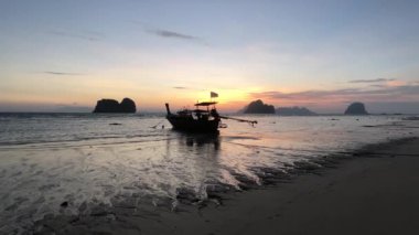 Tayland 'daki Koh Ngai adasında uzun kuyruklu bir tekneyle gün doğumu.