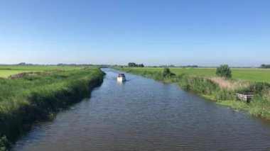 Hollanda, Friesland 'da bir kanalda turizm teknesi.